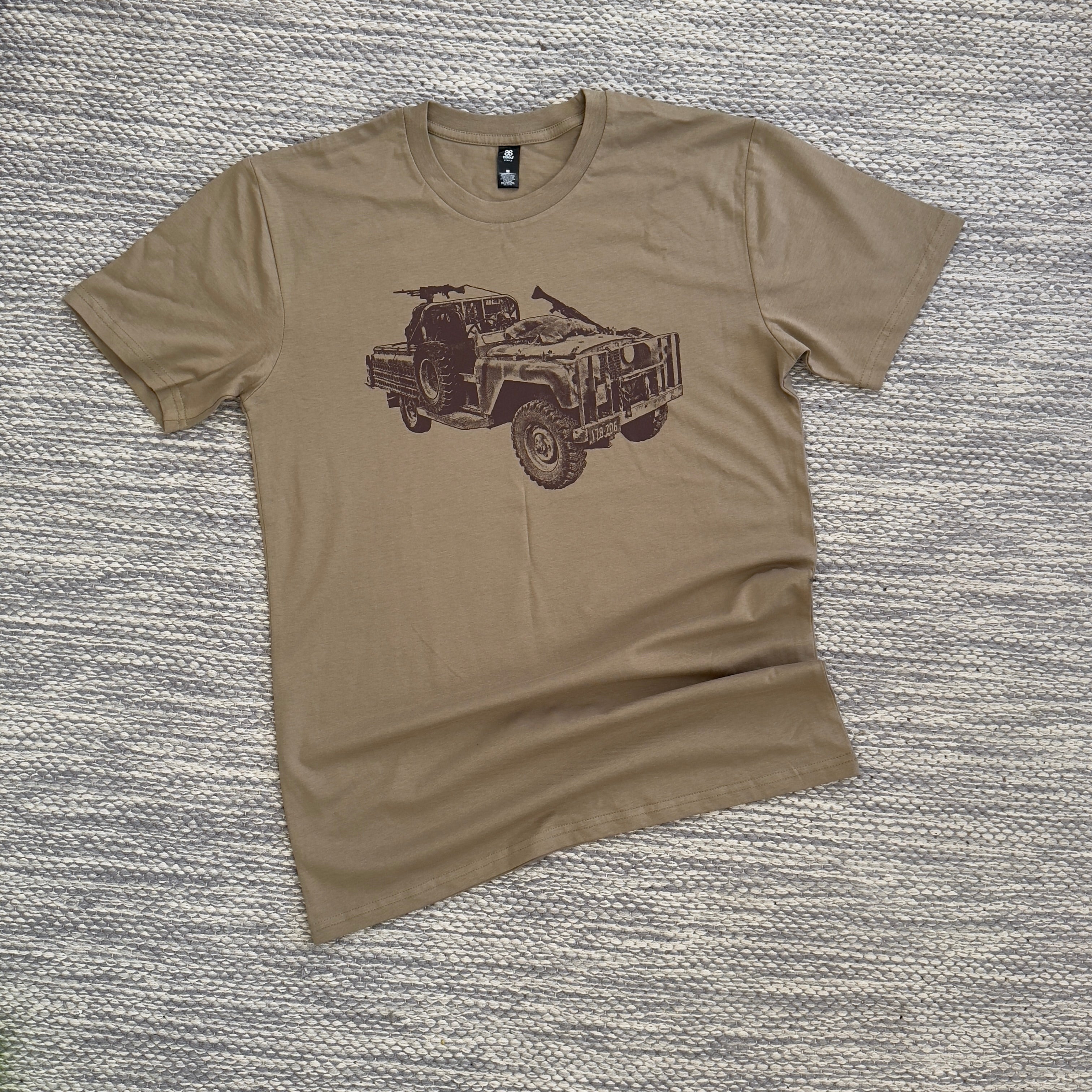 A beige colored t-shirt with a graphic print of a vehicle on the front.