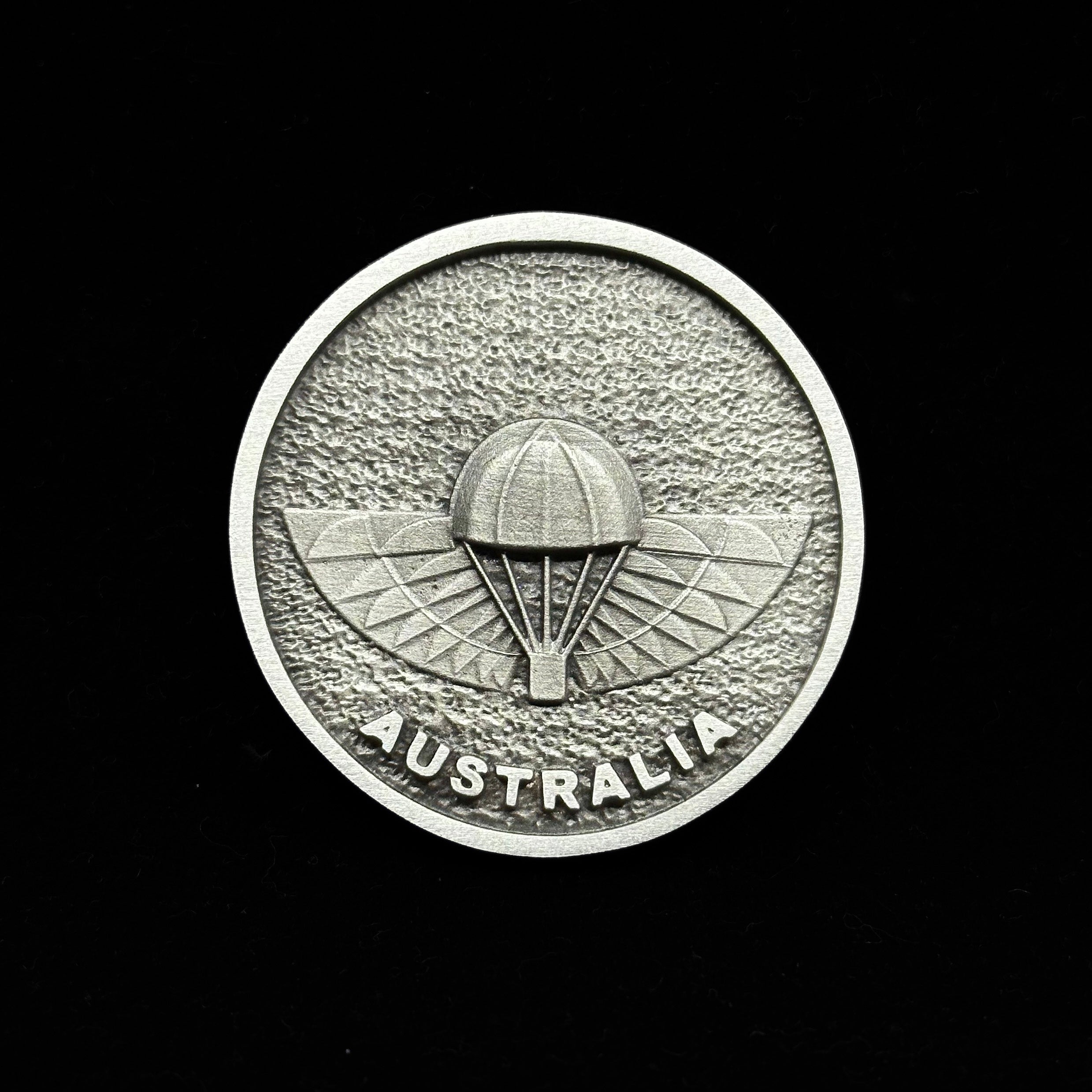 Silver Australia emblem featuring a parachute design on textured background