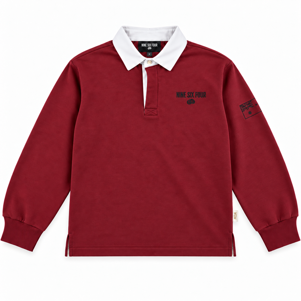 A long-sleeve rugby shirt in deep maroon red with a contrasting white collar, featuring 'NINE SIX FOUR' printed in black on the left chest and a sleeve patch.